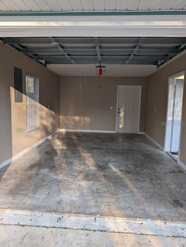 garage featuring electric panel and baseboards