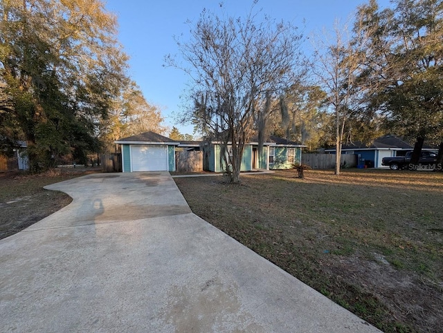 ranch-style house with a garage, a front yard, driveway, and fence