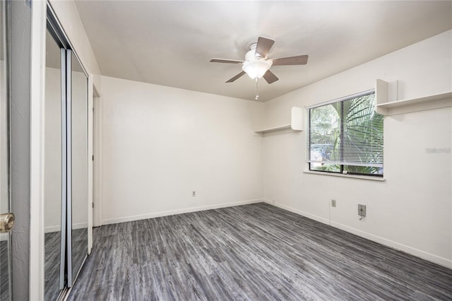 unfurnished bedroom with ceiling fan, a closet, baseboards, and dark wood-type flooring