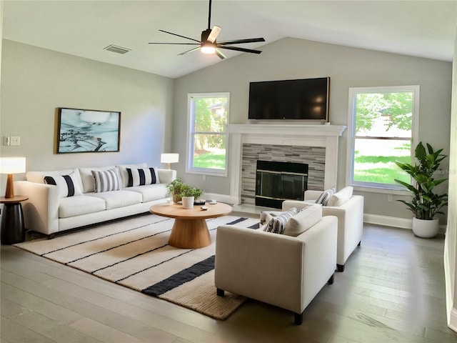 living area featuring lofted ceiling, plenty of natural light, visible vents, and a tile fireplace