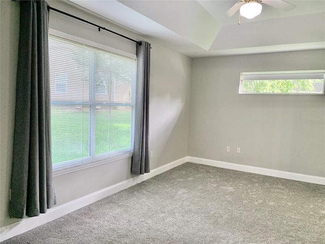 empty room featuring carpet floors, plenty of natural light, baseboards, and ceiling fan