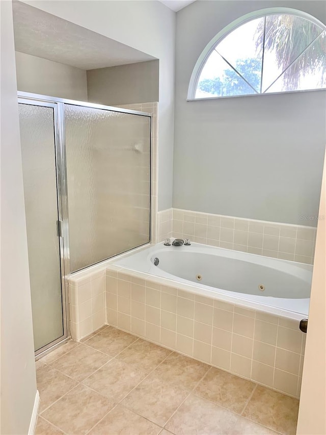 bathroom featuring a whirlpool tub, a stall shower, and tile patterned floors