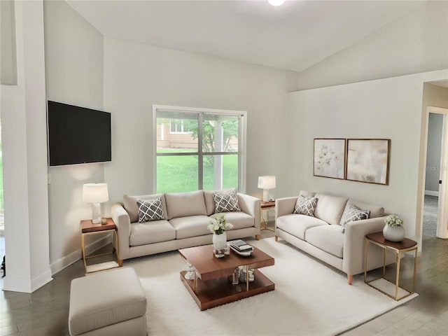 living area featuring lofted ceiling, baseboards, and wood finished floors