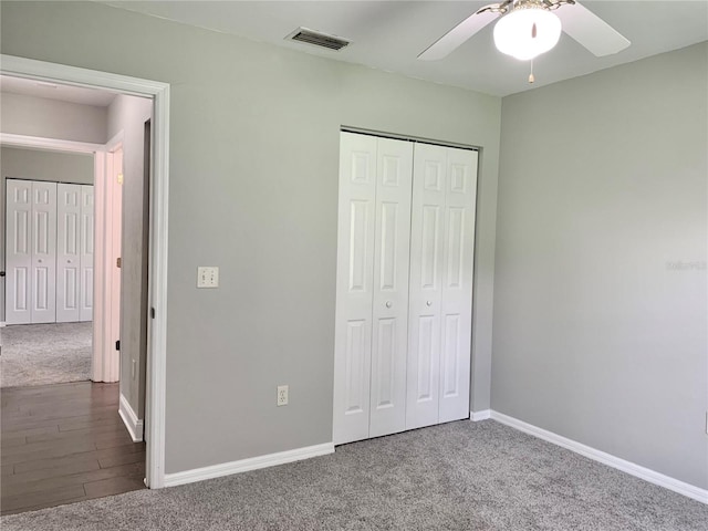 unfurnished bedroom featuring carpet floors, baseboards, visible vents, and a closet