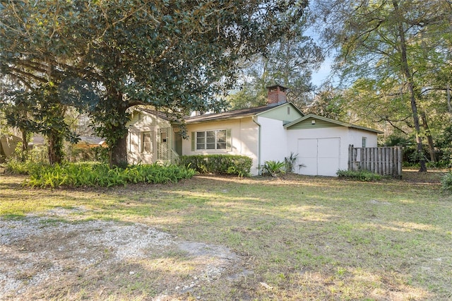 view of front of house with a chimney, a front yard, and fence