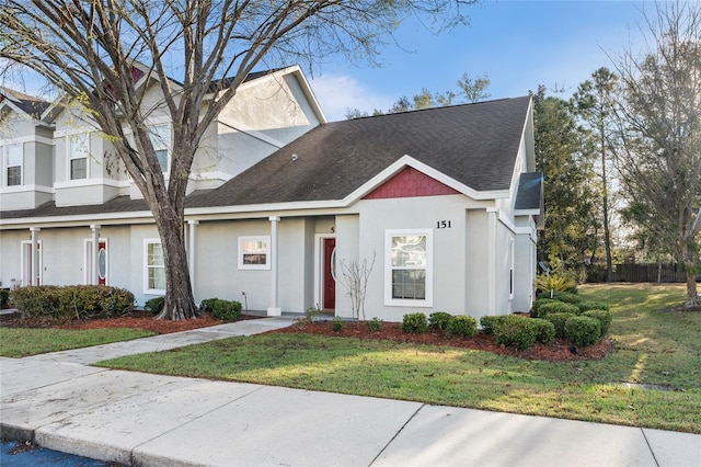 view of property with a front lawn and stucco siding