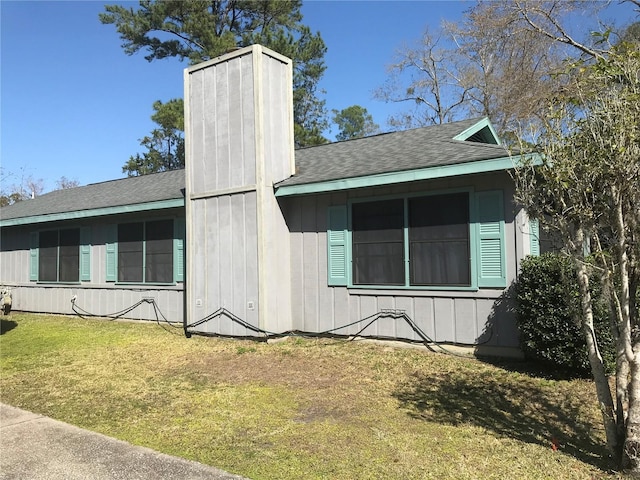 view of property exterior with a yard, a chimney, and roof with shingles