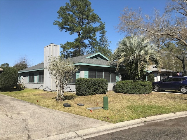 view of front of property featuring a chimney and a front yard