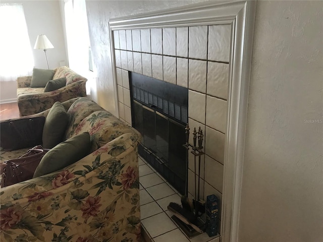 tiled living area featuring a textured wall and a tiled fireplace