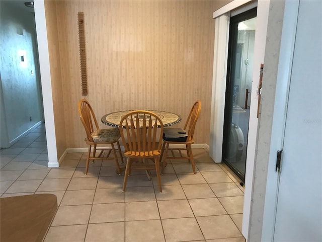 dining space featuring light tile patterned floors and baseboards