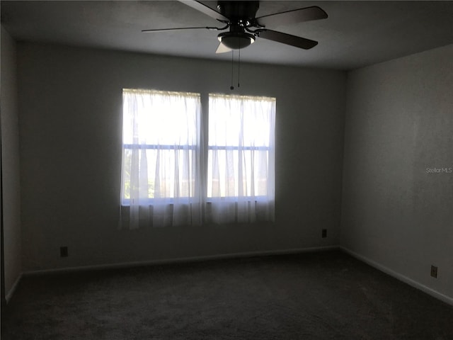 empty room with ceiling fan, baseboards, and carpet flooring