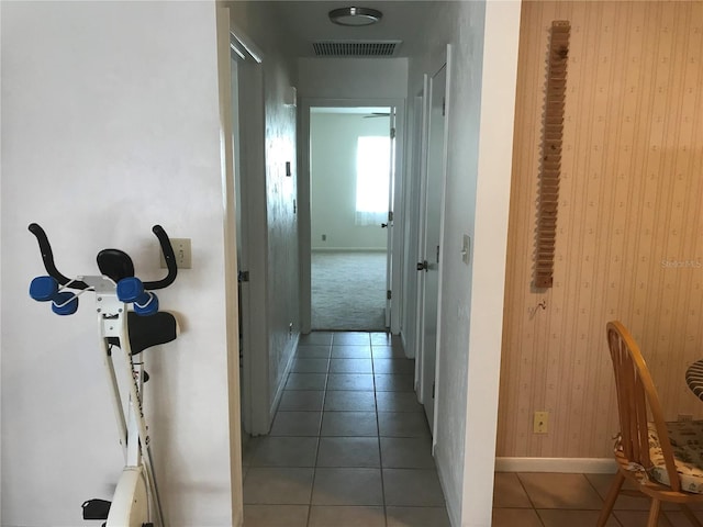 hallway featuring tile patterned flooring, visible vents, and baseboards