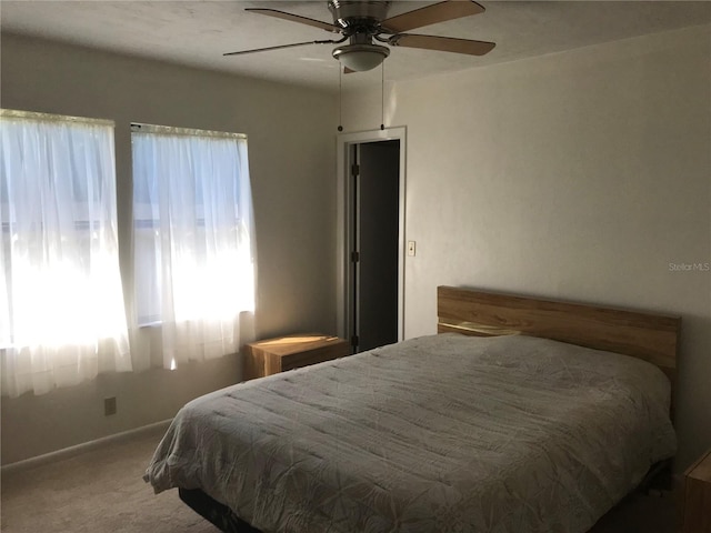 carpeted bedroom featuring ceiling fan and baseboards