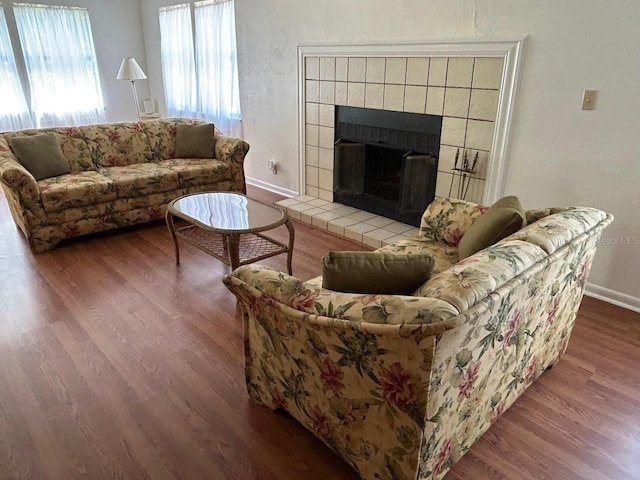 living room featuring wood finished floors, a fireplace, and baseboards
