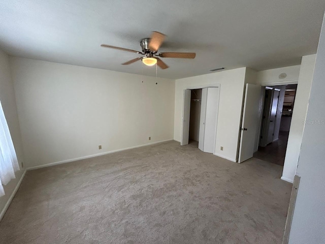 unfurnished bedroom with visible vents, a closet, baseboards, ceiling fan, and light carpet