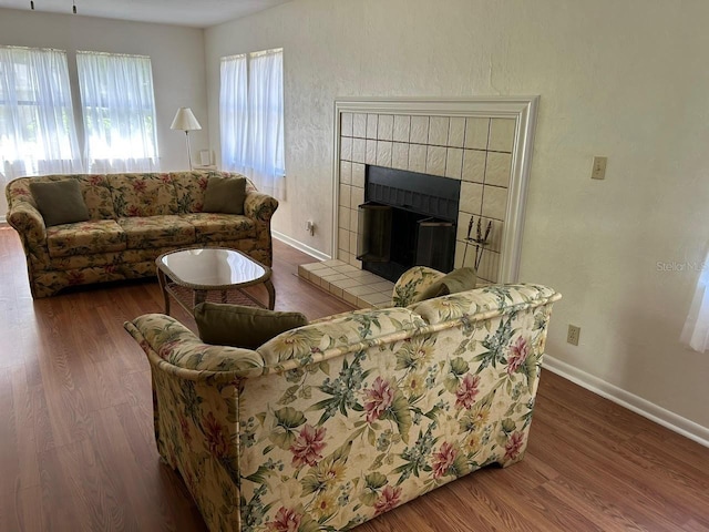 living room with wood finished floors, a fireplace, and baseboards