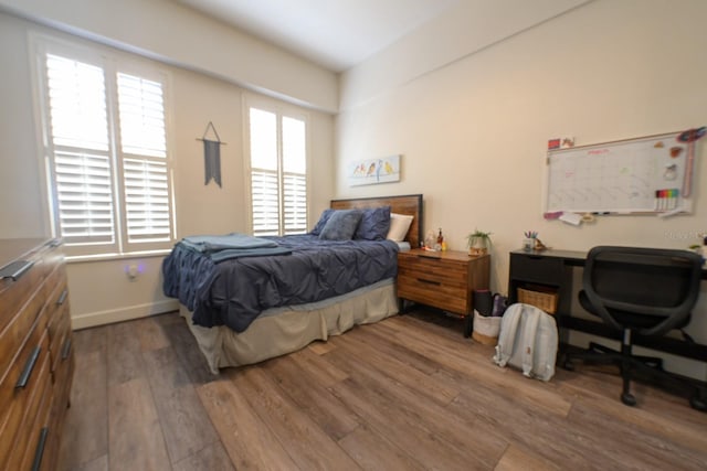 bedroom with wood finished floors and baseboards