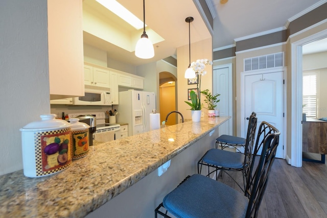 kitchen featuring white appliances, arched walkways, dark wood-style floors, light stone countertops, and crown molding