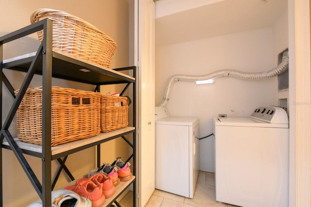 clothes washing area with washing machine and clothes dryer and light tile patterned floors