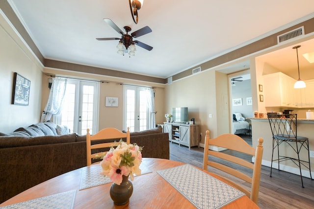 dining area with dark wood-type flooring, french doors, visible vents, and crown molding