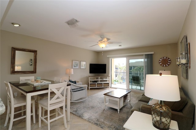 living room featuring tile patterned flooring, visible vents, and ceiling fan