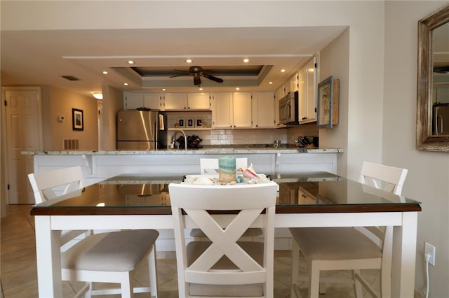 dining area featuring ceiling fan, a tray ceiling, visible vents, and recessed lighting