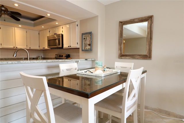 dining area featuring a tray ceiling, ceiling fan, baseboards, and recessed lighting