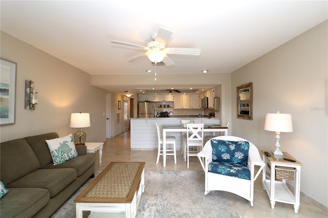 living area featuring light tile patterned floors and ceiling fan