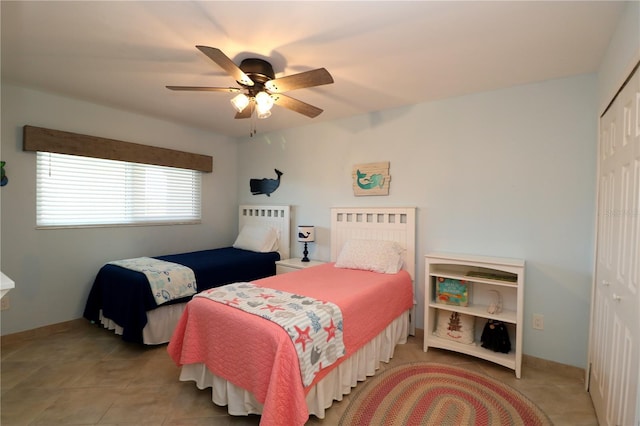 bedroom featuring a closet, tile patterned flooring, a ceiling fan, and baseboards