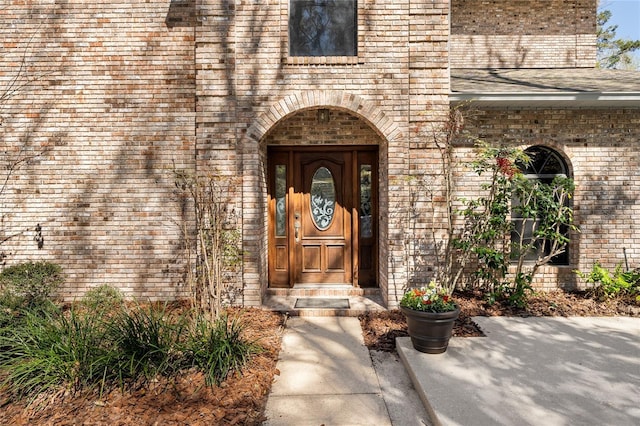 entrance to property featuring brick siding