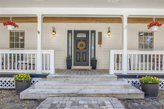 view of exterior entry featuring covered porch