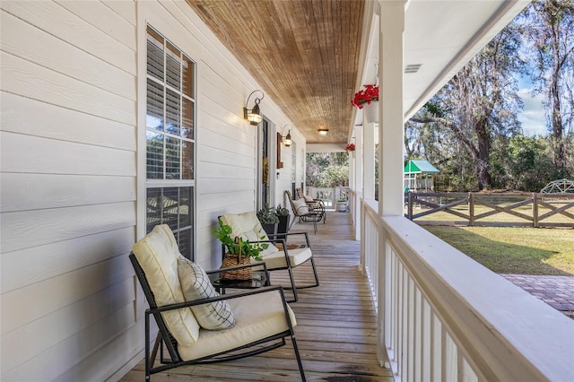 wooden deck with a porch and visible vents