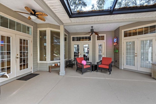 view of patio with glass enclosure, a ceiling fan, and french doors