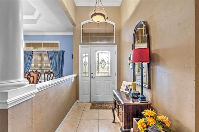 foyer entrance featuring light tile patterned floors, baseboards, ornamental molding, and a textured wall