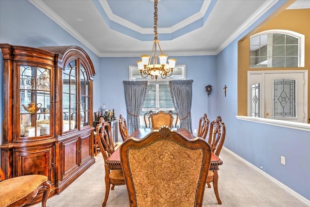 dining space with light carpet, baseboards, a tray ceiling, an inviting chandelier, and crown molding