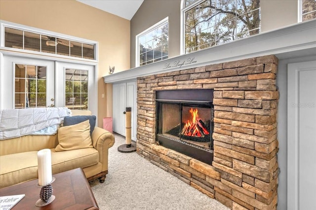 living room with vaulted ceiling, carpet, french doors, and a fireplace