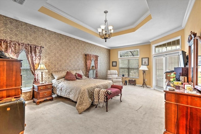 carpeted bedroom with a chandelier, a tray ceiling, visible vents, and ornamental molding