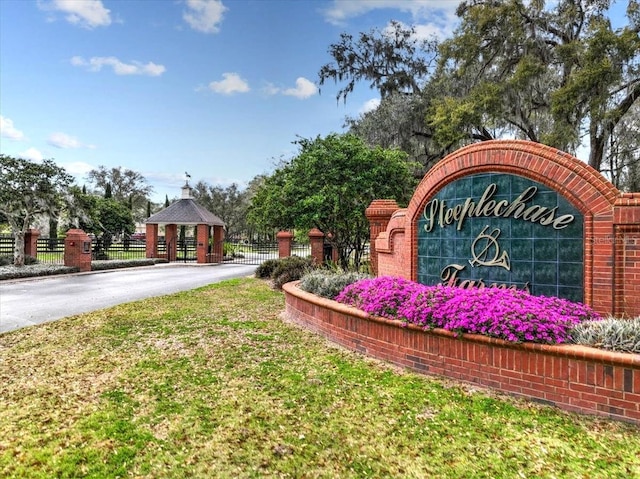 community sign featuring fence and driveway