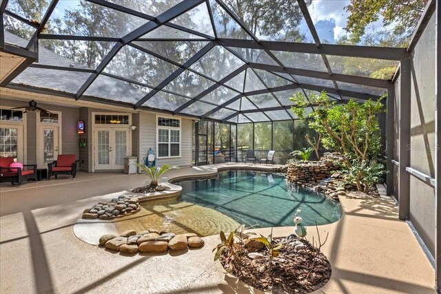 pool with french doors, glass enclosure, and a patio