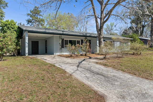 view of front of house featuring driveway, an attached carport, and a front yard