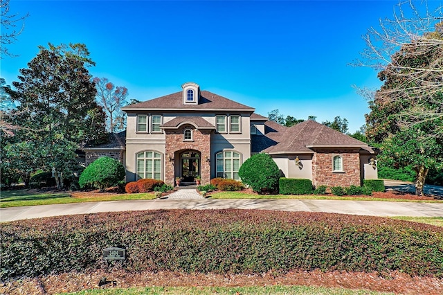 view of front of property featuring stone siding and stucco siding