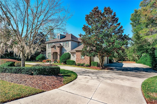 view of front of property with a garage, concrete driveway, stone siding, and stucco siding