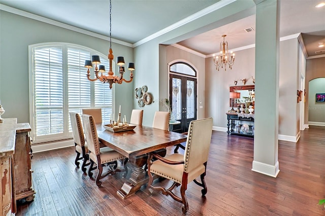 dining room with dark wood-style floors, ornamental molding, baseboards, and an inviting chandelier