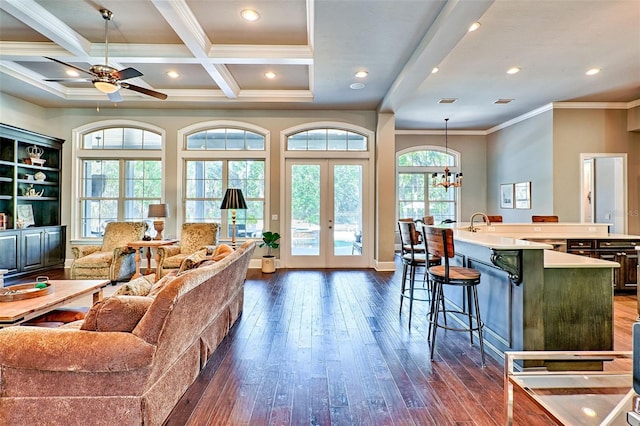 living area featuring coffered ceiling, ornamental molding, dark wood-type flooring, french doors, and beam ceiling