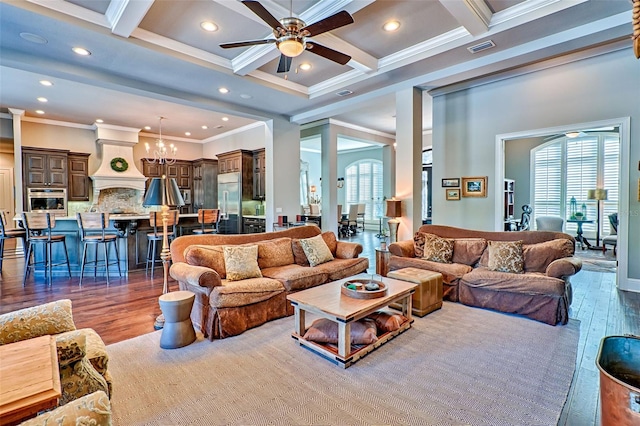 living room with wood finished floors, beam ceiling, visible vents, and ceiling fan with notable chandelier