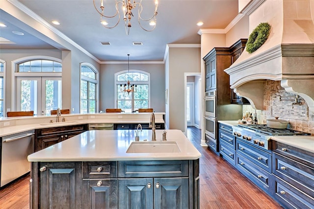 kitchen featuring stainless steel appliances, a sink, and an inviting chandelier