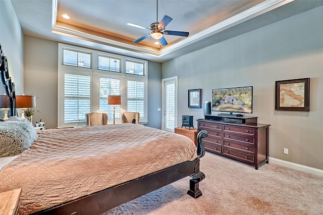 bedroom featuring light carpet, ceiling fan, a raised ceiling, and baseboards