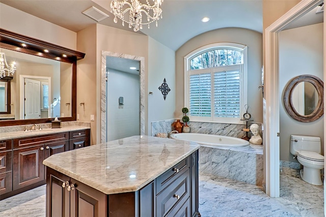 bathroom featuring a chandelier, a garden tub, vanity, and toilet