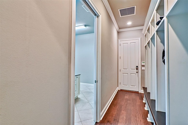 mudroom featuring ornamental molding, visible vents, baseboards, and dark wood-style floors