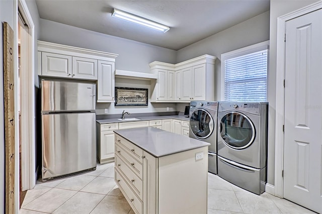 clothes washing area featuring light tile patterned flooring, a sink, cabinet space, and washer and dryer